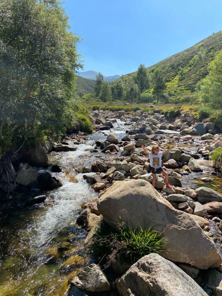 girl in a stream in Scotland, a perfect nature spot for an explore and a picnic