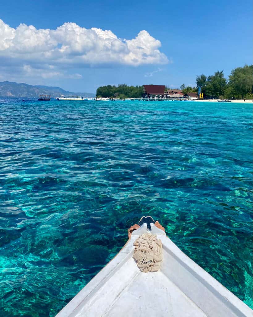 Exploring the Gili Islands with kids in the crystal clear water from the front a small boat. 